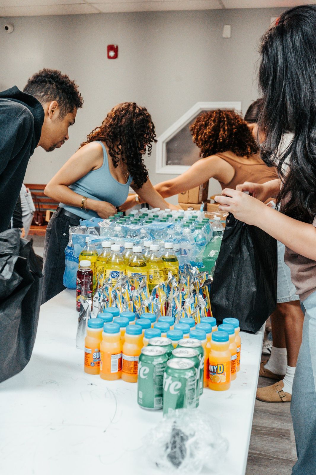 Volunteers packing drinks into outreach bags
