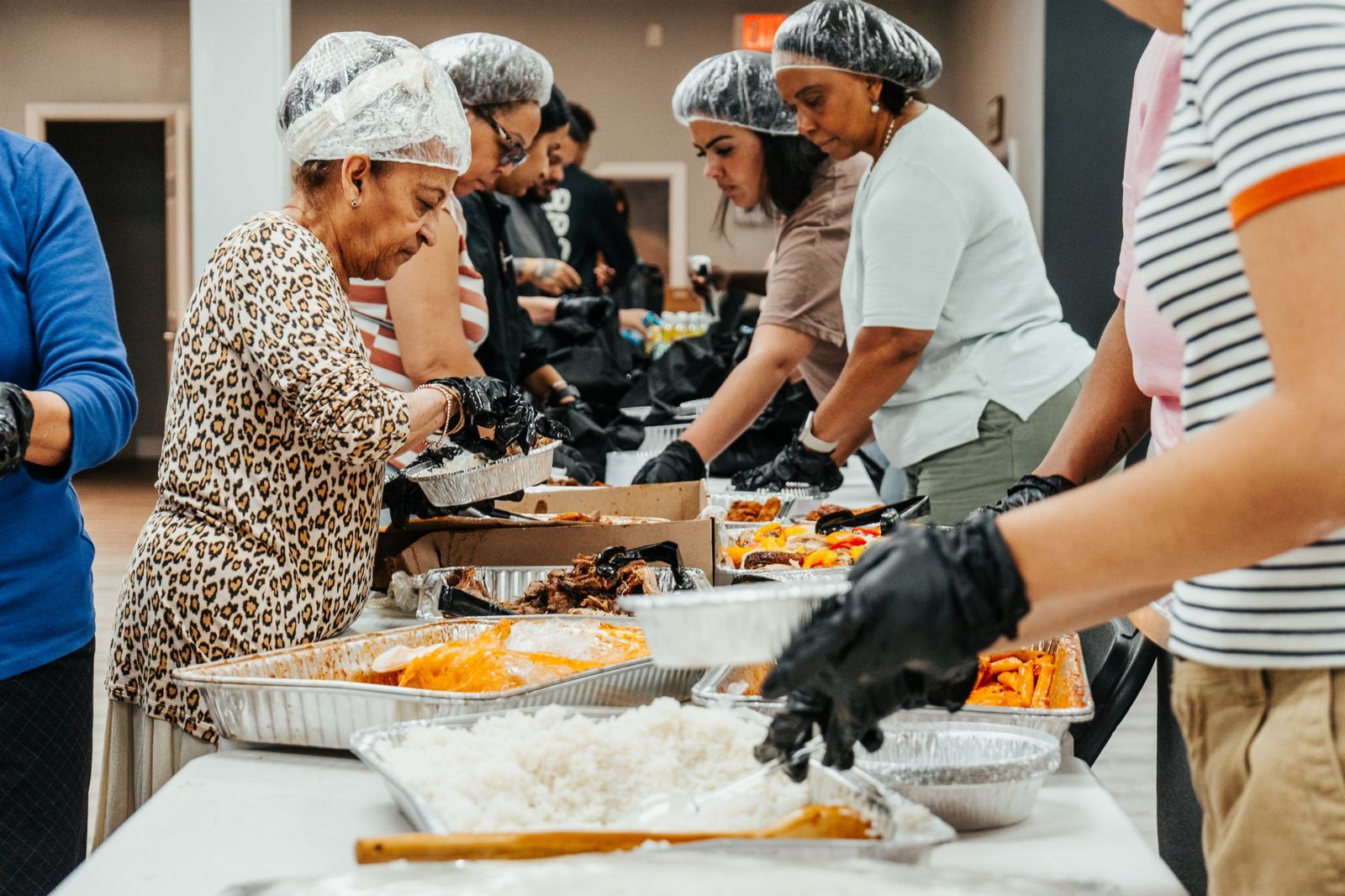 Volunteers packing hot meals on a serving line